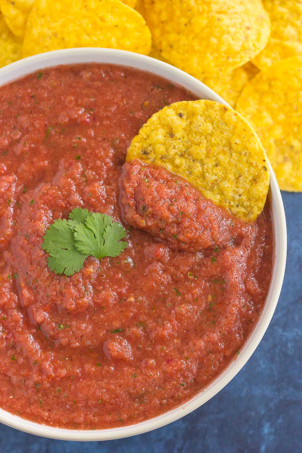 tortilla chip dunked in bowl of restaurant style salsa