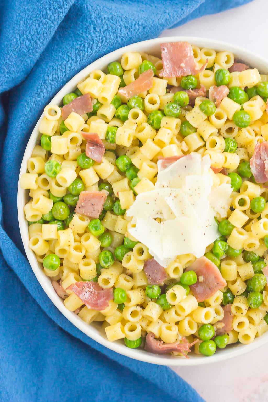 An overhead view of a bowl of peas and prosciutto pasta. 