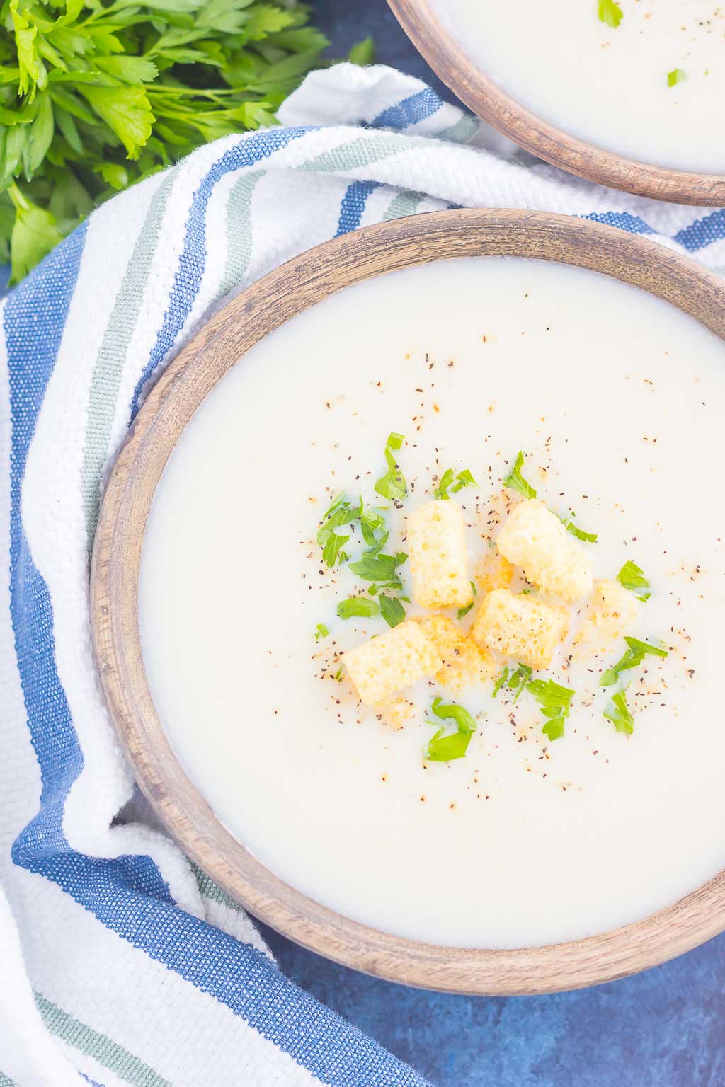 Overhead view of a bowl of cheesy cauliflower soup. 
