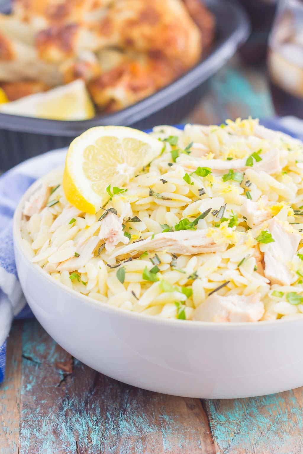 bowl of lemon orzo pasta salad garnished with a lemon wedge