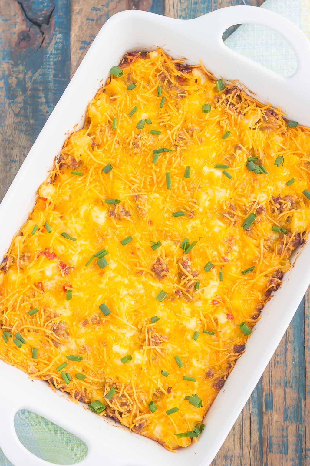overhead view of a sausage hashbrown breakfast casserole in a white casserole dish. 