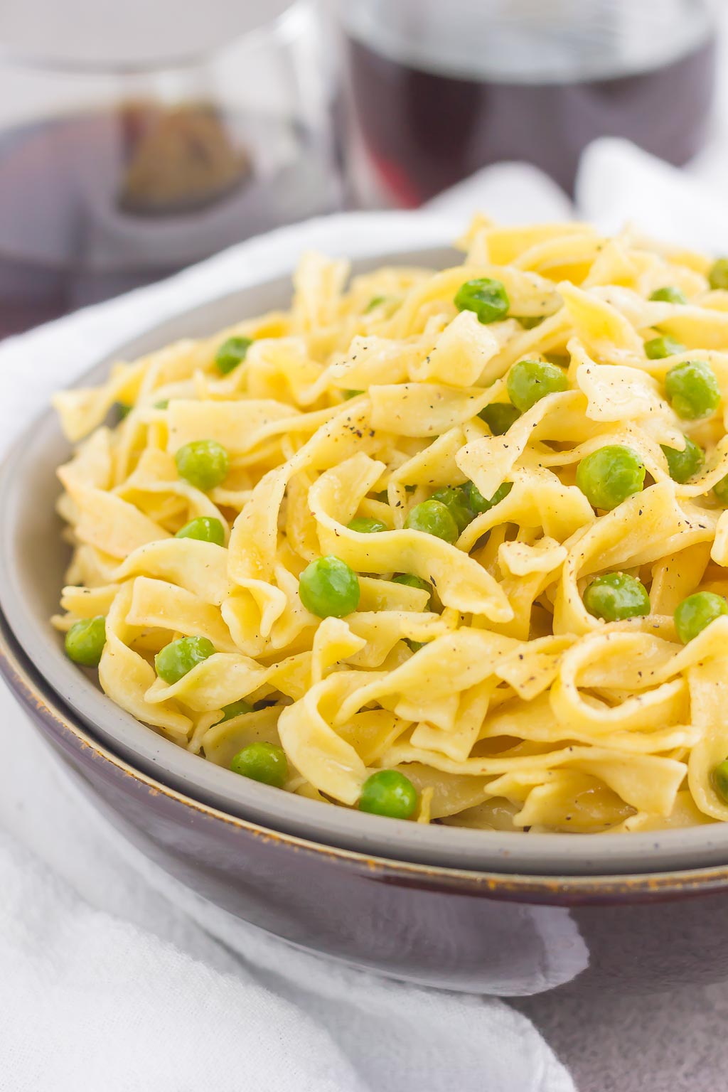 an egg noodle side dish with peas in a large bowl 