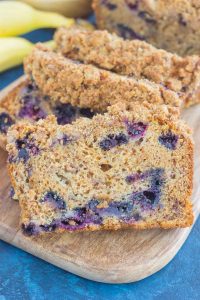 slices of blueberry banana bread on cutting board