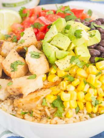 Skip the takeout and make your own Easy Chicken Burrito Bowl at home! It's loaded with juicy chicken, cilantro lime rice, black beans, corn, fresh tomatoes, and avocado. Drizzled with a soy sauce marinade and ready in no time, this meal is sure to become a family favorite!