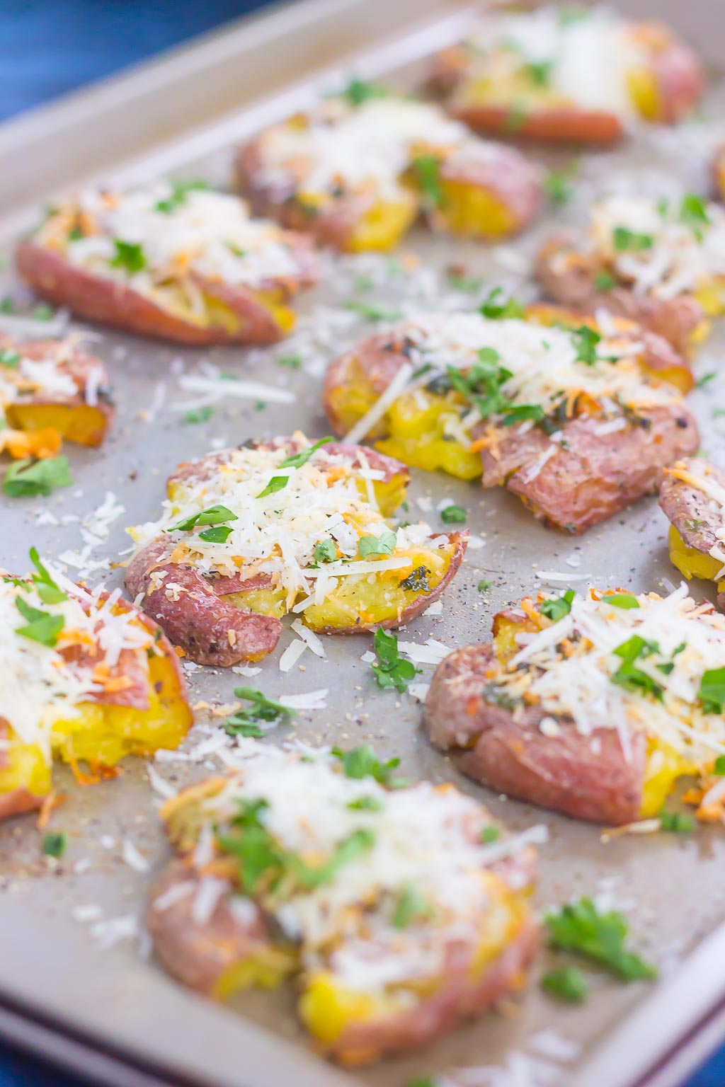 side view of smashed garlic potatoes on a baking tray