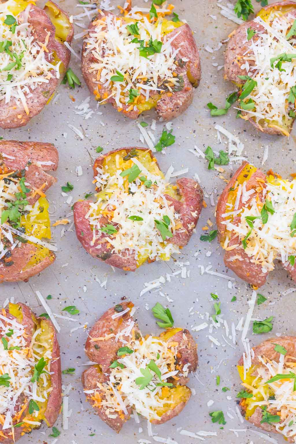 overhead view of garlic smashed potatoes on a baking tray