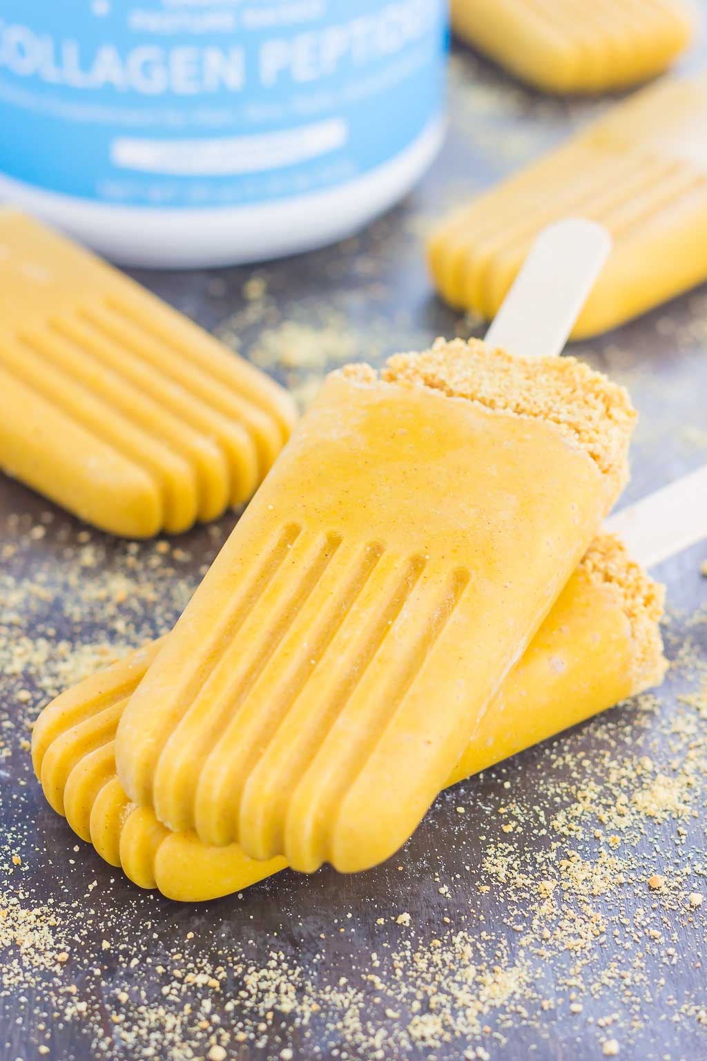These Pumpkin Pie Pops taste just like the classic pie, but in frozen form. Sprinkled with a graham cracker crust and filled with healthier ingredients, these creamy pops are the perfect dessert for the season! #pumpkin #pumpkinpops #pumpkinpie #frozendessert #dessert #pumpkindessert #falldessert 