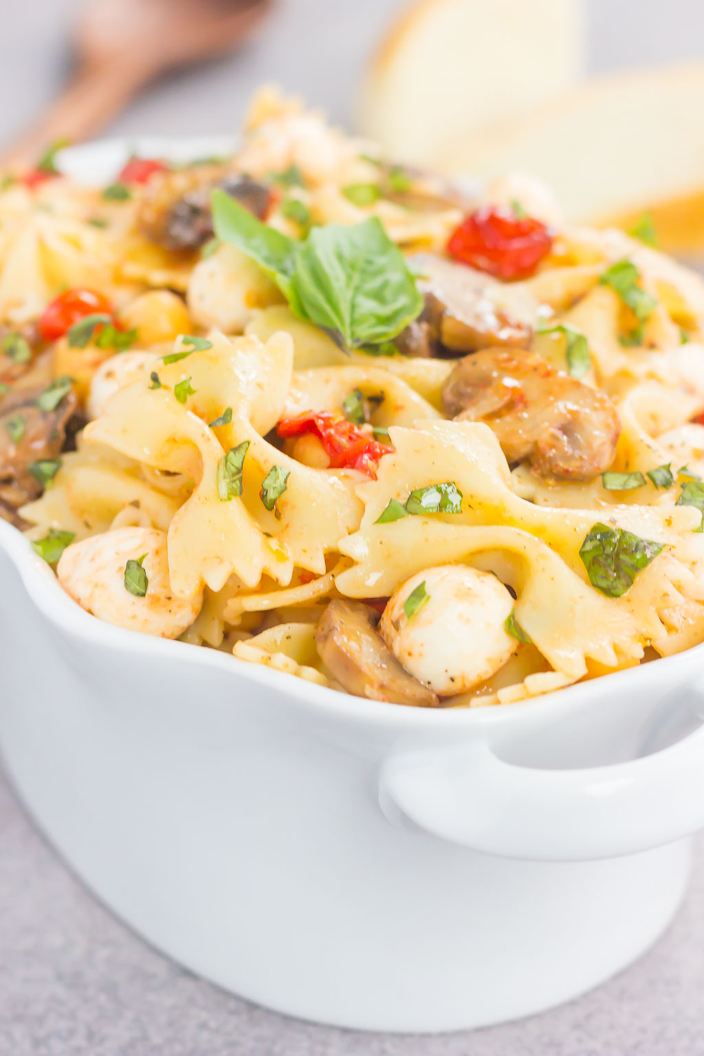 This Roasted Mushroom and Tomato Pasta Salad is a flavorful dish that comes together in minutes. Fresh mushrooms and cherry tomatoes are roasted until tender and then tossed with chickpeas, mozzarella and pasta in a light, white balsamic dressing. Bursting with flavor and perfect for a light lunch or dinner, you'll be making this pasta salad all year long!