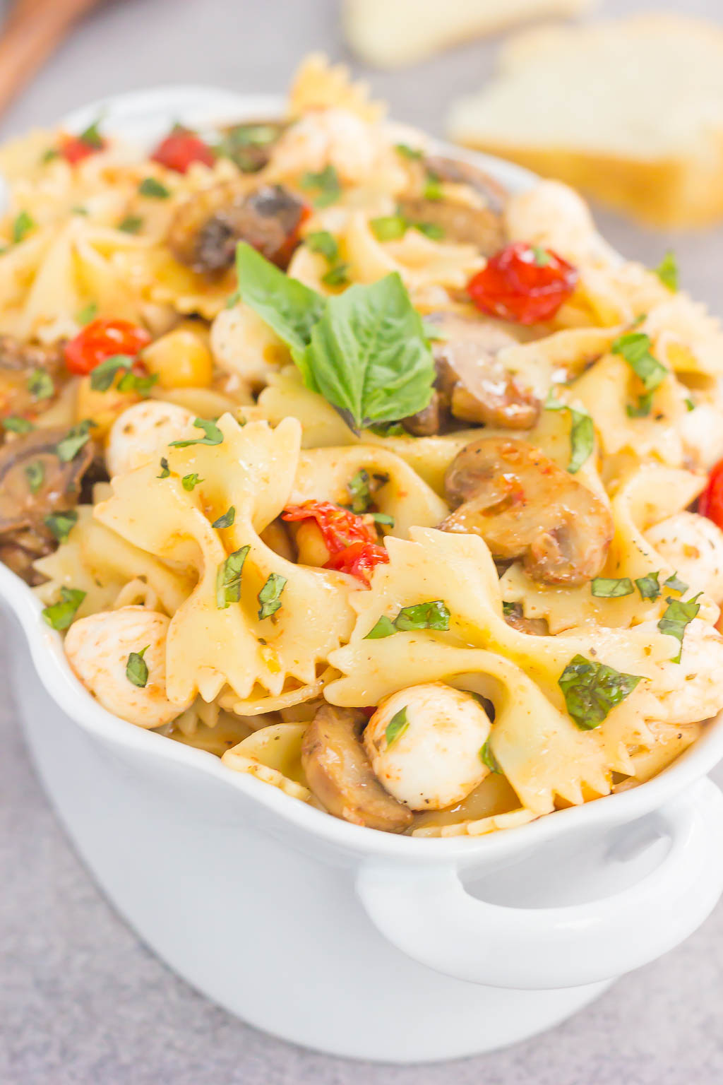 This Roasted Mushroom and Tomato Pasta Salad is a flavorful dish that comes together in minutes. Fresh mushrooms and cherry tomatoes are roasted until tender and then tossed with chickpeas, mozzarella and pasta in a light, white balsamic dressing! #pasta #pastasalad #tomato #tomatosalad #mushrooms #mushroompastasalad #pastasaladrecipe #saladrecipe #sidedish