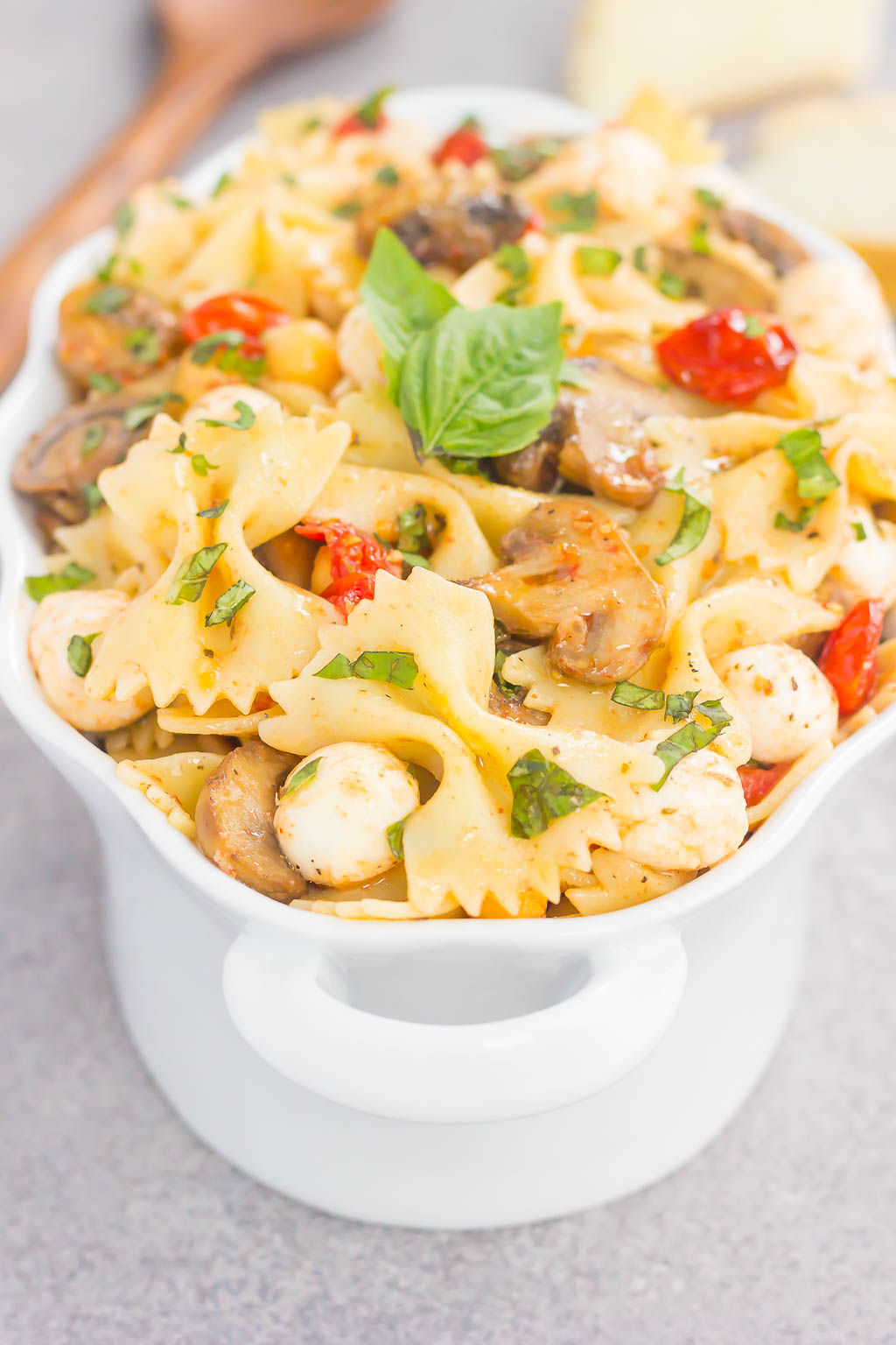 This Roasted Mushroom and Tomato Pasta Salad is a flavorful dish that comes together in minutes. Fresh mushrooms and cherry tomatoes are roasted until tender and then tossed with chickpeas, mozzarella and pasta in a light, white balsamic dressing. Bursting with flavor and perfect for a light lunch or dinner, you'll be making this pasta salad all year long!