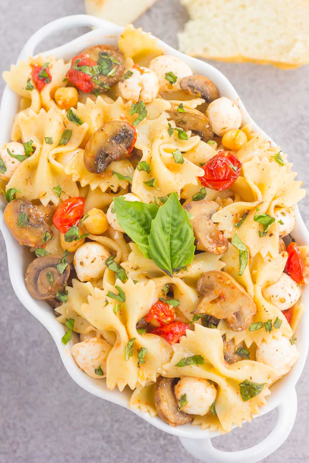 This Roasted Mushroom and Tomato Pasta Salad is a flavorful dish that comes together in minutes. Fresh mushrooms and cherry tomatoes are roasted until tender and then tossed with chickpeas, mozzarella and pasta in a light, white balsamic dressing. Bursting with flavor and perfect for a light lunch or dinner, you'll be making this pasta salad all year long!