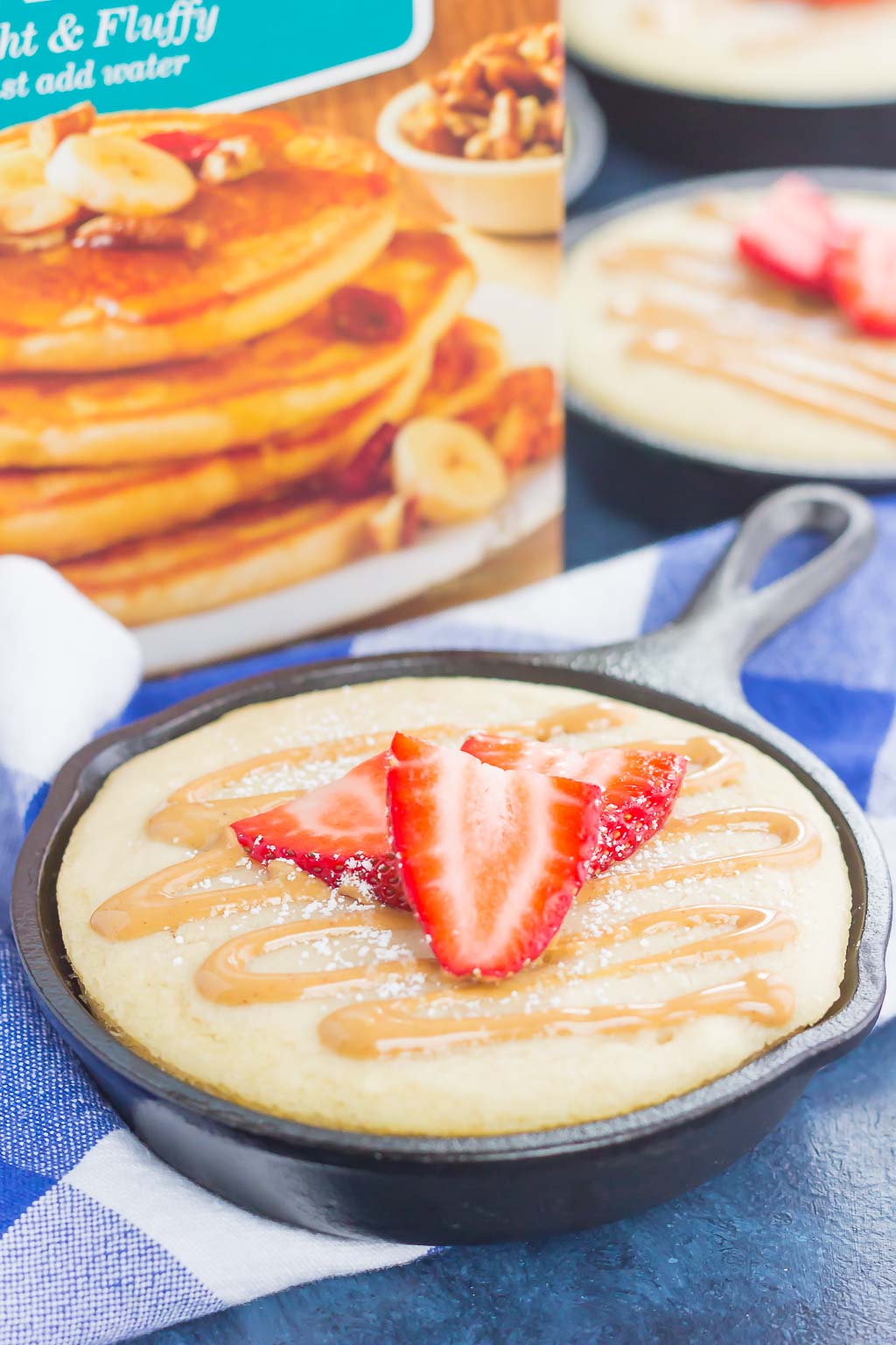 Peanut Butter and Jelly Baked Pancakes are a warm and cozy breakfast to get you going in the mornings. Drizzled with a sweet peanut butter syrup and topped with fresh strawberries, this easy breakfast is ready in less than 30 minutes and perfect for the whole family! #pancakes #bakedpancakes #peanutbutter #peanutbutterpancakes #peanutbuttersyrup #pbjpancakes #breakfast #easybreakfast