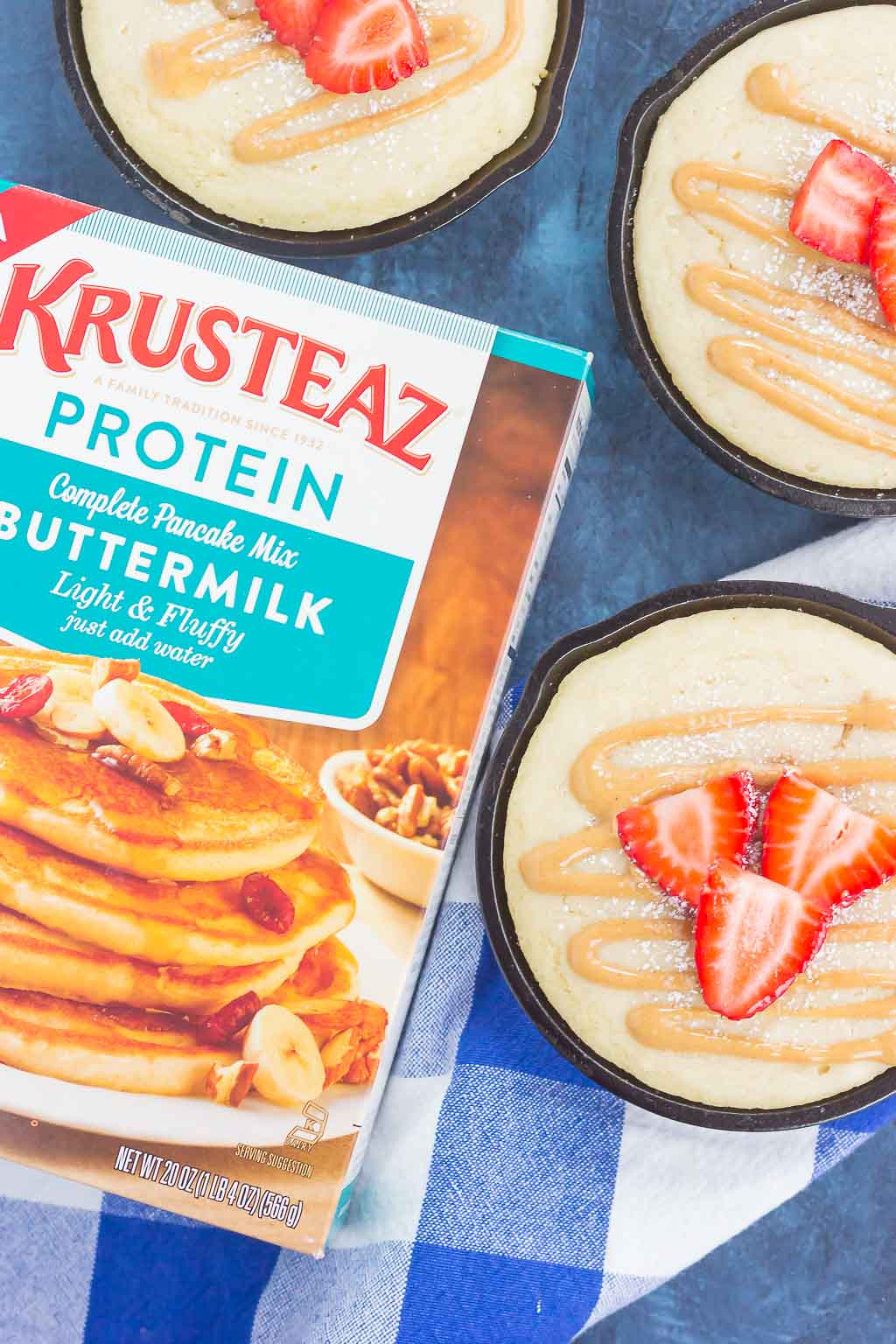 Peanut Butter and Jelly Baked Pancakes are a warm and cozy breakfast to get you going in the mornings. Fluffy, buttermilk pancake batter is swirled with sweet strawberry jelly and then baked in mini cast iron skillets. Drizzled with a sweet peanut butter syrup and topped with fresh strawberries, this easy breakfast is ready in less than 30 minutes and perfect for the whole family!
