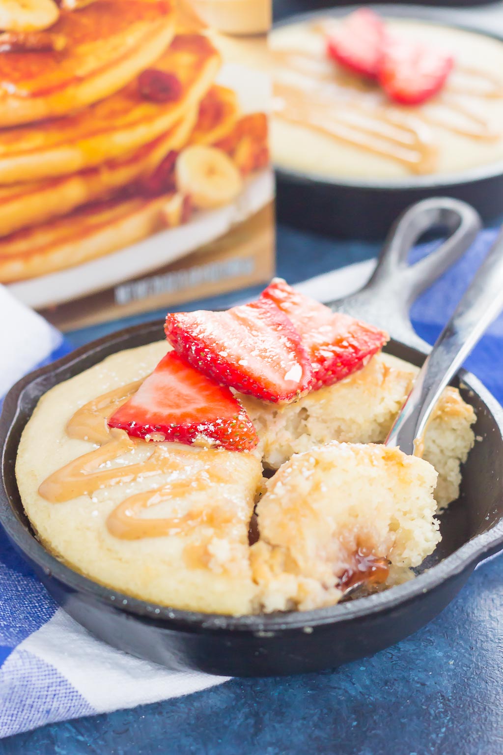 Peanut Butter and Jelly Baked Pancakes are a warm and cozy breakfast to get you going in the mornings. Fluffy, buttermilk pancake batter is swirled with sweet strawberry jelly and then baked in mini cast iron skillets. Drizzled with a sweet peanut butter syrup and topped with fresh strawberries, this easy breakfast is ready in less than 30 minutes and perfect for the whole family!