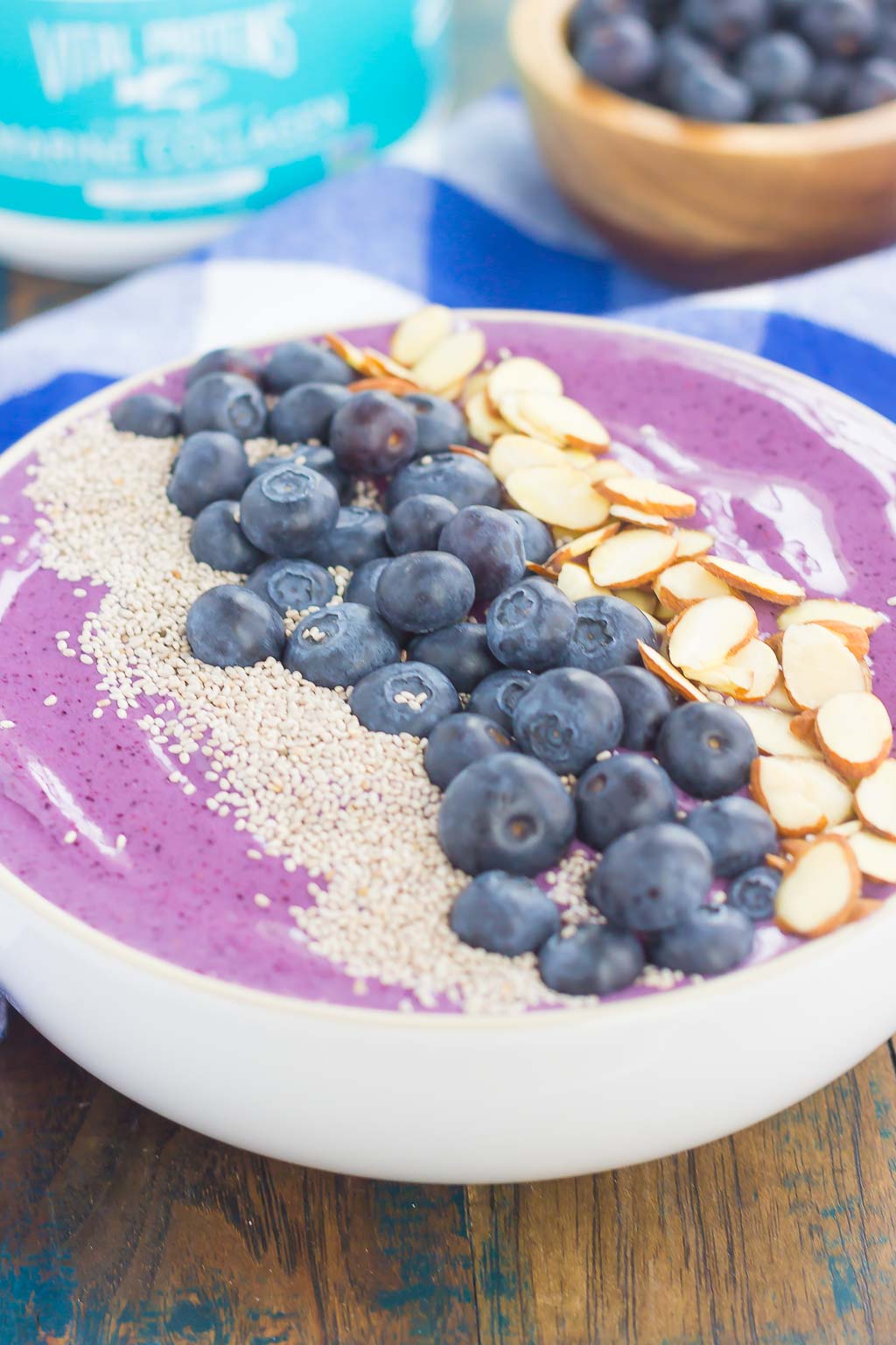 A blueberry smoothie bowl topped with fresh blueberries, chia seeds, and sliced almonds. 