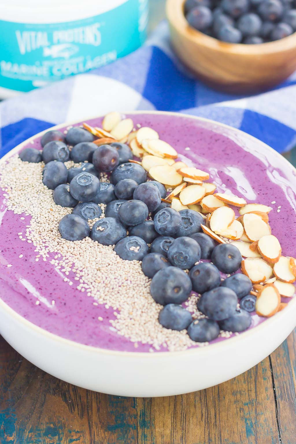 A blueberry banana smoothie bowl topped with fresh blueberries, chia seeds, and sliced almonds.