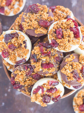 These Chocolate Cherry Granola Cups are the perfect bite for when you want something sweet. Smooth dark chocolate and creamy white chocolate cups are topped with crunchy granola and dried cherries. With no oven needed and ready in minutes, these cups make a delicious dessert or snack!