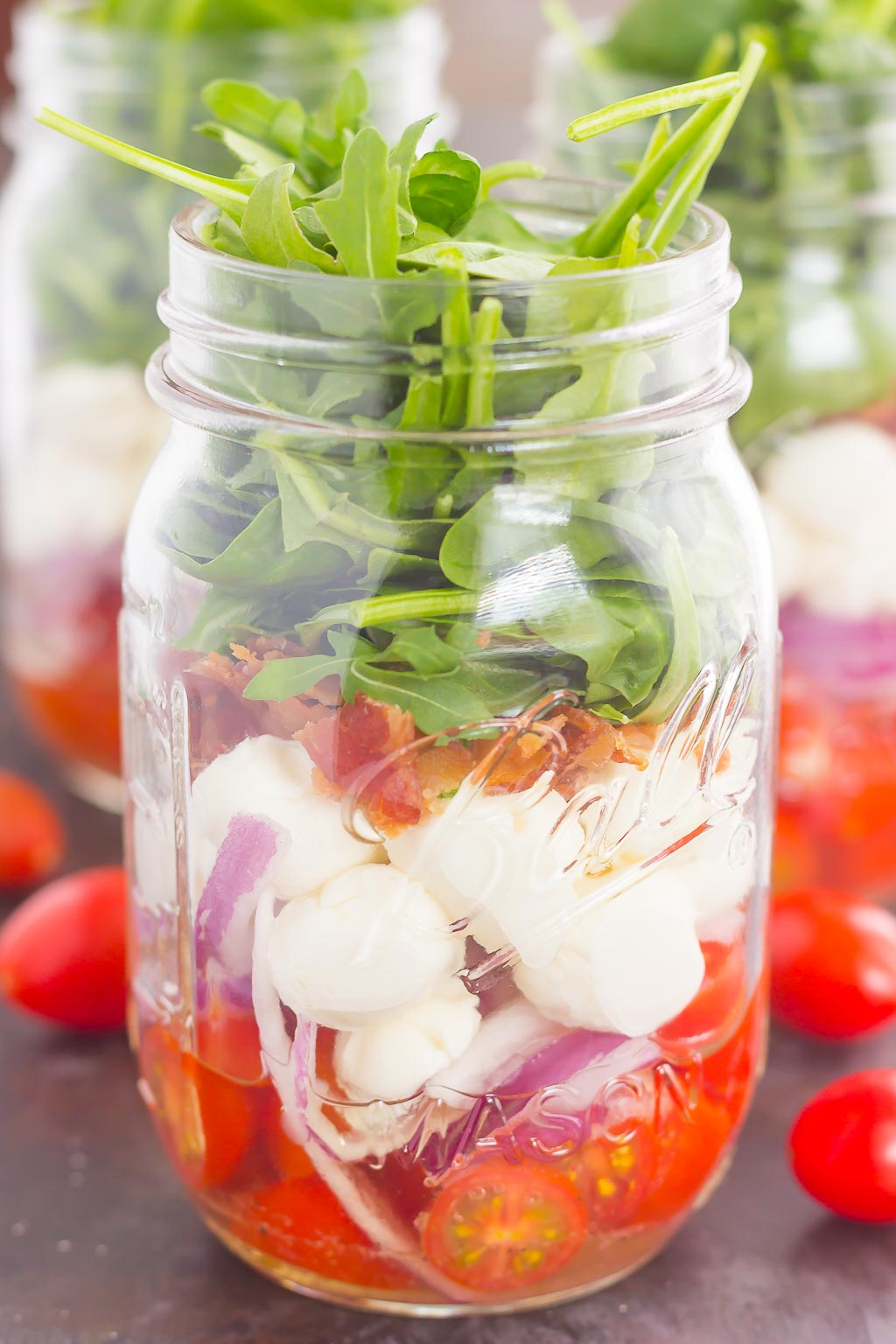 Caprese Mason Jar Salad makes a deliciously easy meal that's perfect for just about any day. Classic caprese ingredients are layered in a mason jar, along with some red onion and crisp bacon for extra flavor. Great for meal prepping and perfect as a grab-n-go lunch, you'll love the ease and taste of this classic salad that's fun to make and even better to eat!