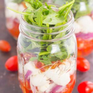 Caprese Mason Jar Salad makes a deliciously easy meal that's perfect for just about any day. Classic caprese ingredients are layered in a mason jar, along with some red onion and crisp bacon for extra flavor. Great for meal prepping and perfect as a grab-n-go lunch, you'll love the ease and taste of this classic salad that's fun to make and even better to eat!