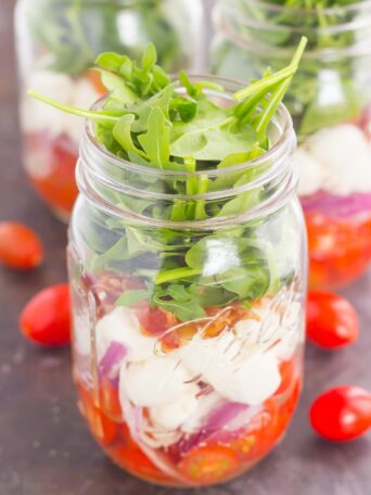 Caprese Mason Jar Salad makes a deliciously easy meal that's perfect for just about any day. Classic caprese ingredients are layered in a mason jar, along with some red onion and crisp bacon for extra flavor. Great for meal prepping and perfect as a grab-n-go lunch, you'll love the ease and taste of this classic salad that's fun to make and even better to eat!