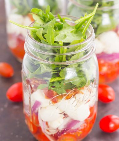 Caprese Mason Jar Salad makes a deliciously easy meal that's perfect for just about any day. Classic caprese ingredients are layered in a mason jar, along with some red onion and crisp bacon for extra flavor. Great for meal prepping and perfect as a grab-n-go lunch, you'll love the ease and taste of this classic salad that's fun to make and even better to eat!