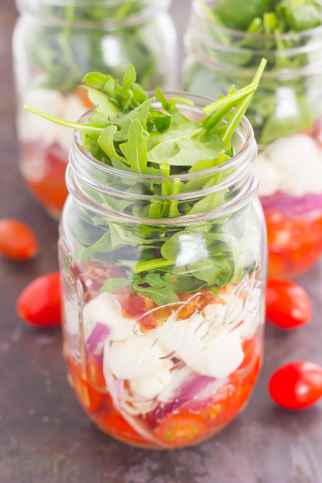 Caprese Mason Jar Salad makes a deliciously easy meal that's perfect for just about any day. Great for meal prepping and perfect as a grab-n-go lunch, you'll love the ease and taste of this classic salad that's fun to make and even better to eat! #salad #capresesalad #masonjar #masonjarsalads #masonjarsaladrecipe #capresemasonjarsalad #capreserecipe #healthysalad #healthylunch