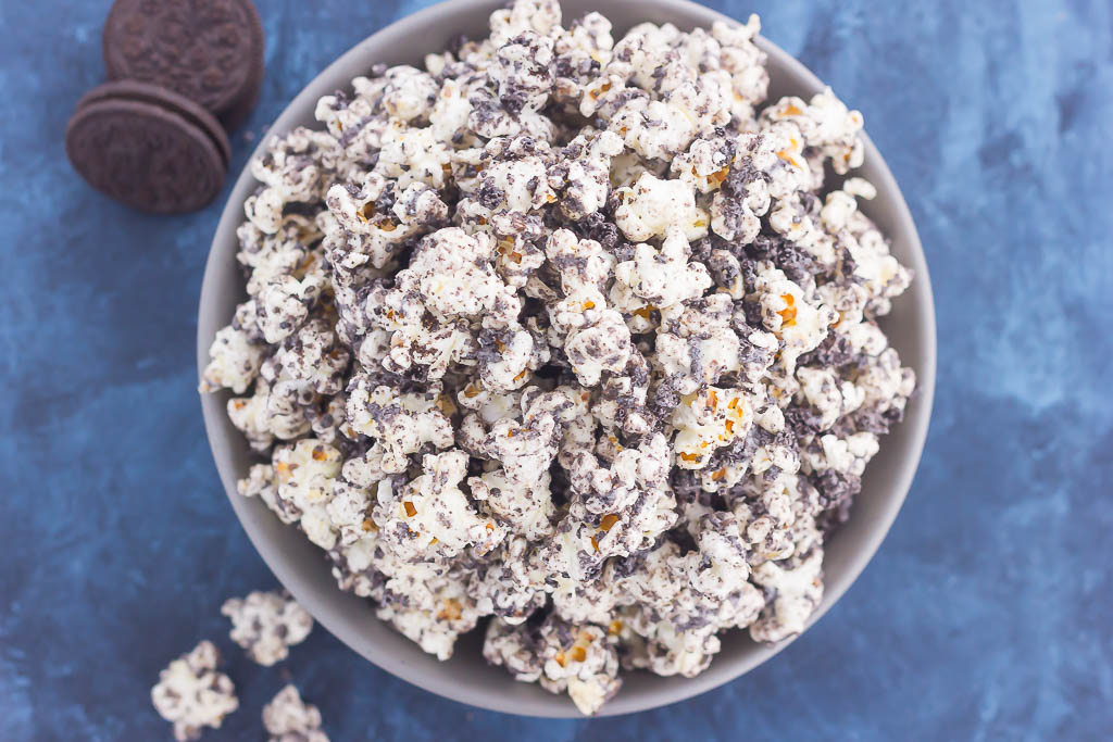 This Cookies and Cream Popcorn is an easy sweet treat that's ready in less than 10 minutes. Popcorn is coated with creamy white chocolate and then sprinkled with crushed Oreo cookies. Fast, easy, and perfect to munch on, this is the ultimate treat for when those snack attacks strike!