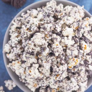 This Cookies and Cream Popcorn is an easy sweet treat that's ready in less than 10 minutes. Popcorn is coated with creamy white chocolate and then sprinkled with crushed Oreo cookies. Fast, easy, and perfect to munch on, this is the ultimate treat for when those snack attacks strike!