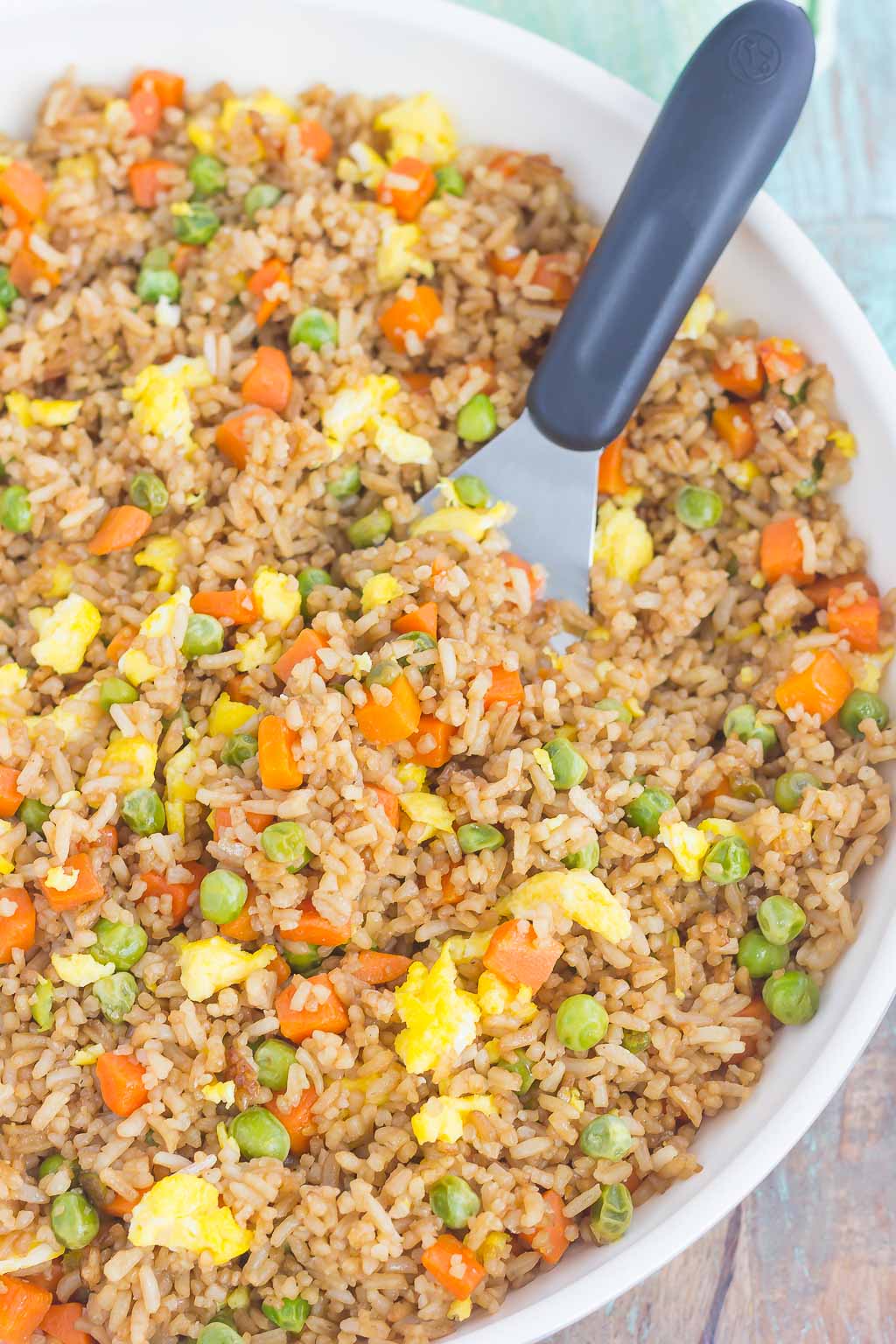 A large bowl of quick fried rice with a spatula 