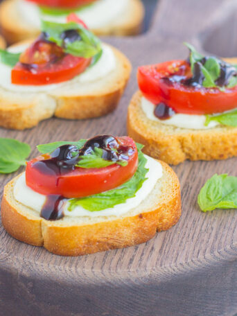Caprese Bites make an easy appetizer that's ready in minutes. Fresh basil, mozzarella cheese, ripe tomatoes and a drizzle of balsamic glaze top toasted bread slices for the perfect bite. If you love caprese flavors, then this simple snack was made for you!