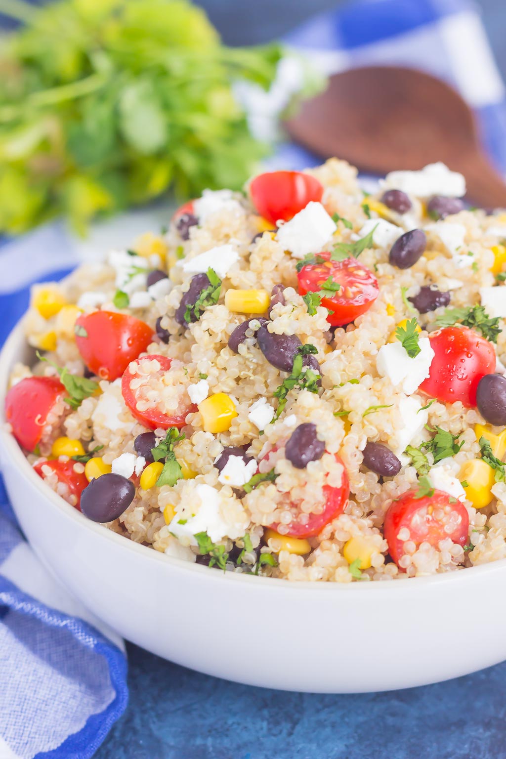 Side view of quinoa salad with black beans and corn in a large white serving bowl. 