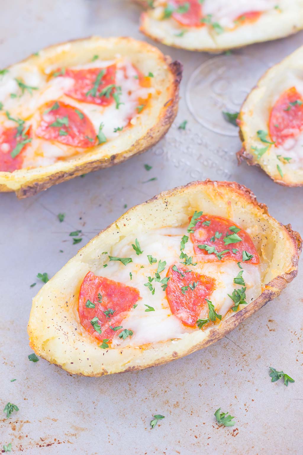 Loaded with pizza sauce, fresh mozzarella cheese, pepperoni and seasonings, these Pizza Potato Skins are sure to be a crowd-pleasing appetizer or snack! #potatoskins #pizza #pizzapotatoskins #potatoskinrecipe #appetizer #easyappetizer