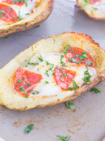 Three potato skin pizzas on a baking sheet.