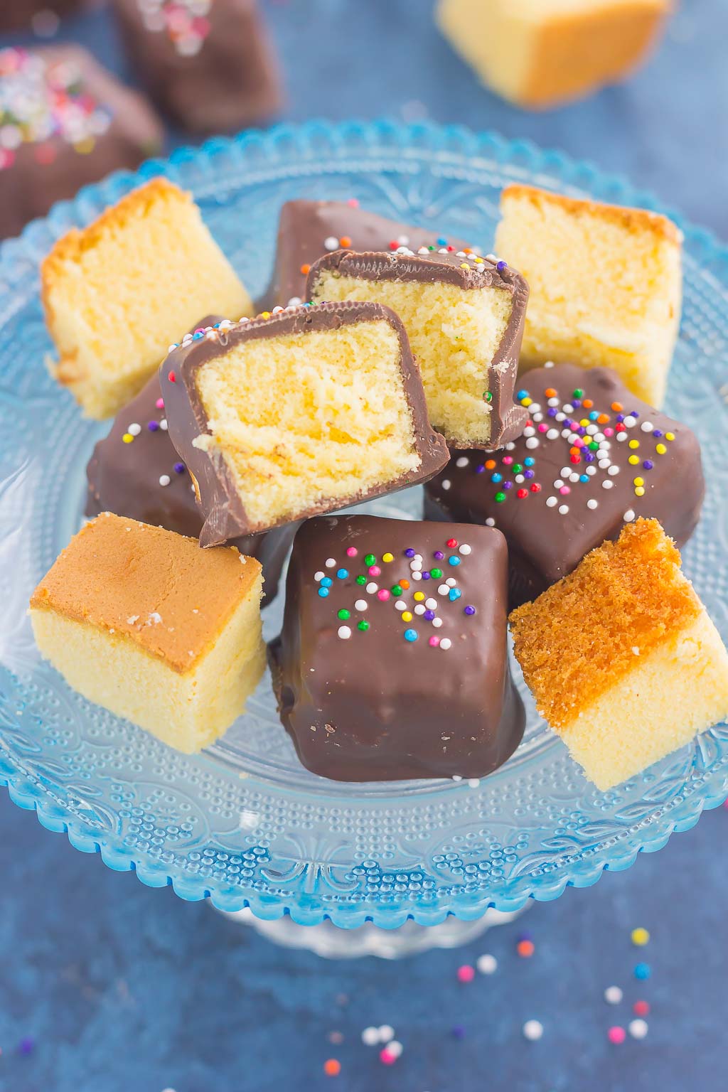 Chocolate-covered pound cake bites on a glass cake stand. 