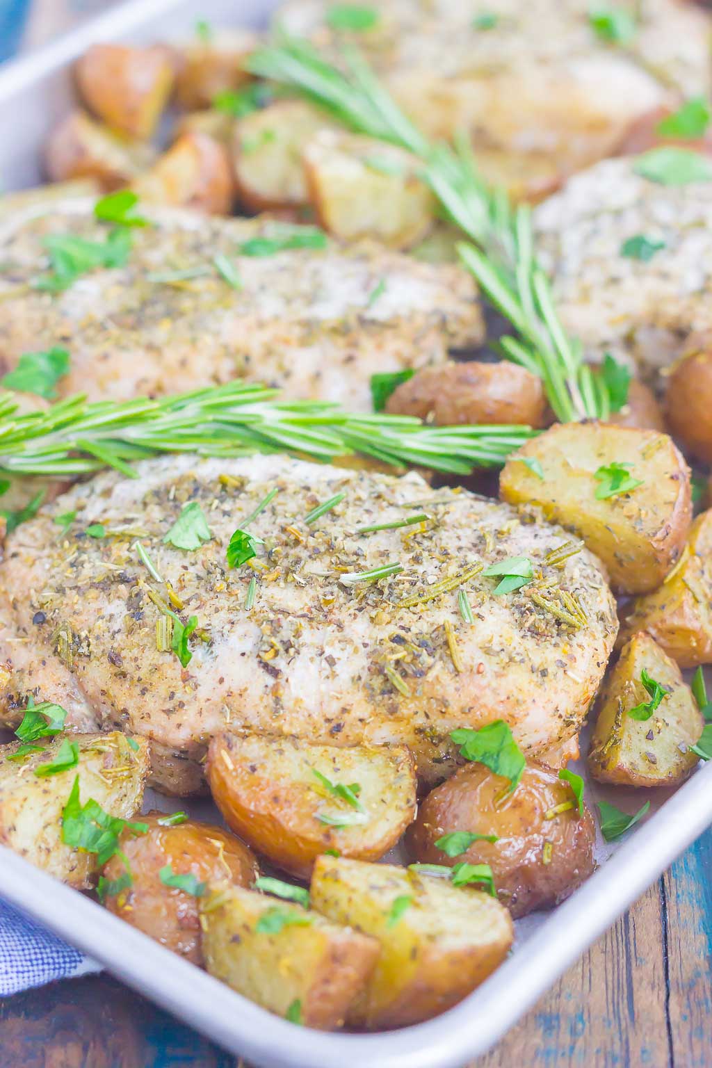 rosemary pork chops and potatoes on a baking tray