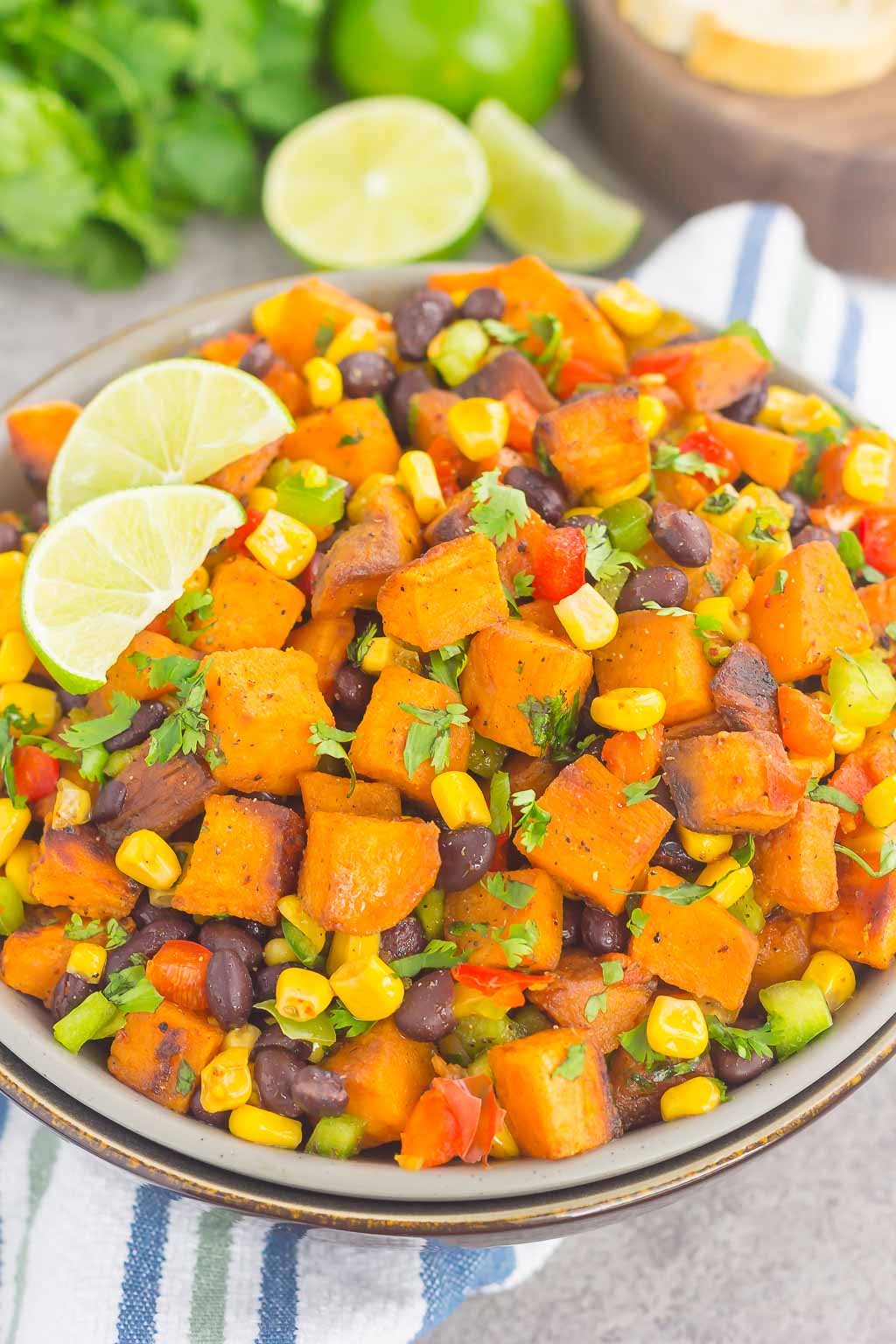 dish of sweet potato black bean salad garnished with lime wedges