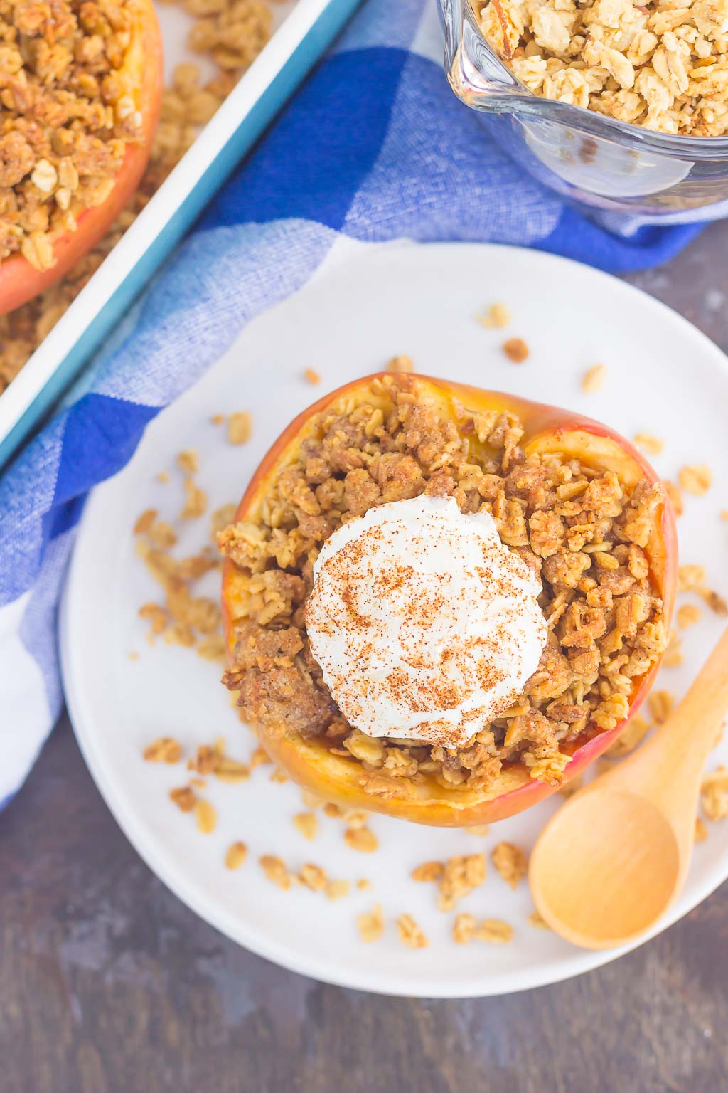 overhead view of a granola stuffed baked apple on a white plate 