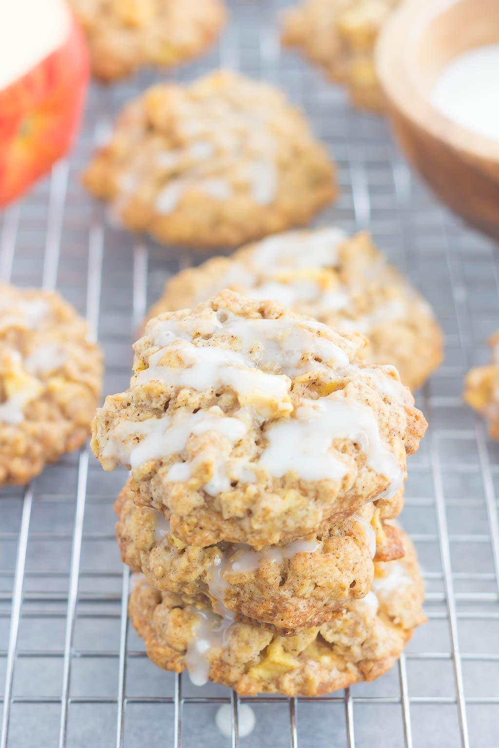 glazed apple oatmeal cookies stacked on a wire cooling rack