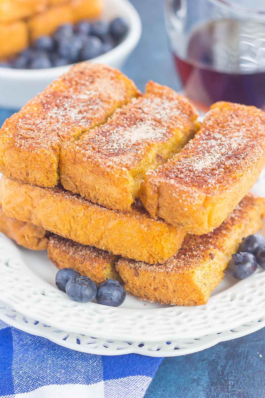 piled of baked french toast sticks on white plate