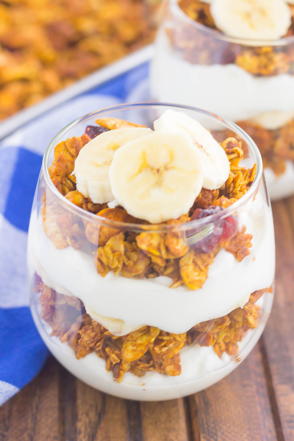 yogurt and pumpkin granola and banana slices layered in a glass