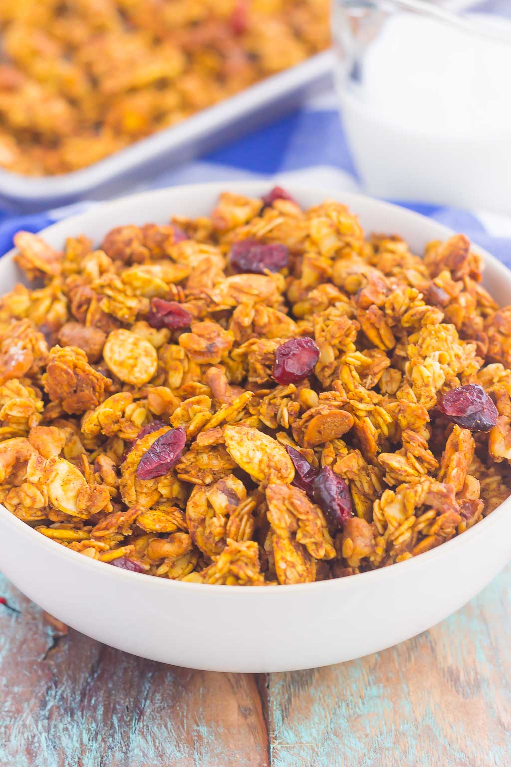 This Pumpkin Spice Granola is a delicious way to savor the flavors of fall. Hearty oats, crunchy walnuts, dried cranberries and fall spices give this granola both texture and flavor. It's simple to make and perfect to eat by the handful, with milk, or on top of yogurt or ice cream! #granola #pumpkingranola #homemadegranola #pumpkinbreakfast #pumpkinsnack #healthygranola