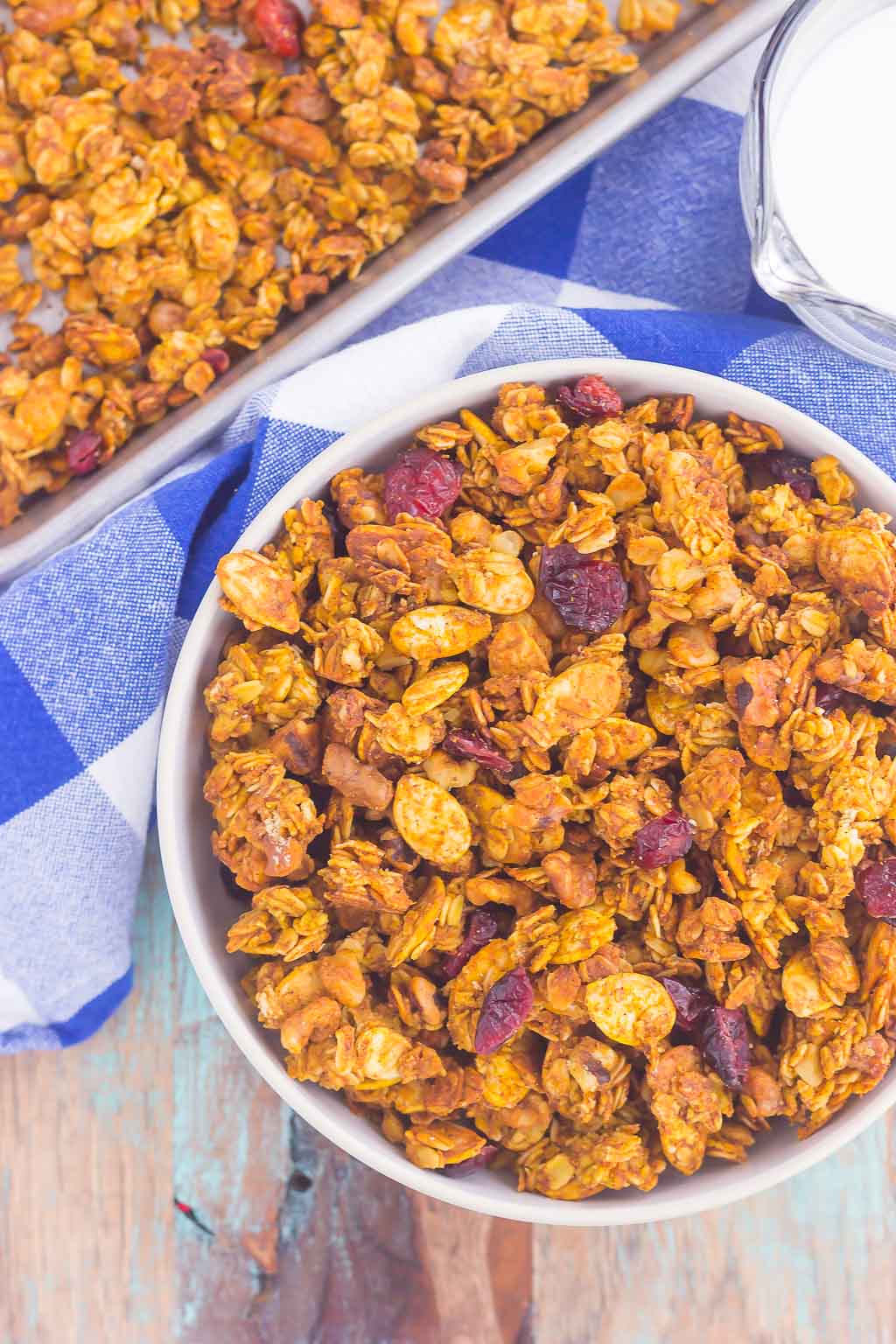 This Pumpkin Spice Granola is a delicious way to savor the flavors of fall. Hearty oats, crunchy walnuts, dried cranberries and fall spices give this granola both texture and flavor. It's simple to make and perfect to eat by the handful, with milk, or on top of yogurt or ice cream! #granola #pumpkingranola #homemadegranola #pumpkinbreakfast #pumpkinsnack #healthygranola