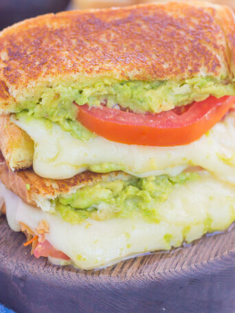 Tomato, Avocado and Mozzarella Grilled Cheese is filled with fresh tomato slices, smashed avocado and creamy mozzarella cheese. Grilled until golden on the outside and melty on the inside, this sandwich is perfect to pair with soup for an easy lunch or dinner!