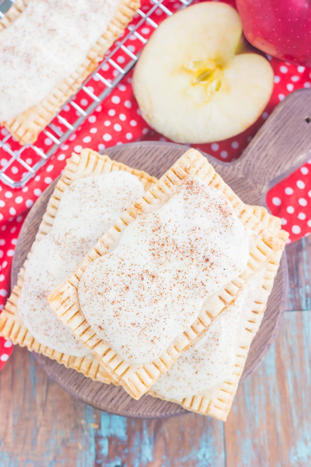 These Apple Pie Pop Tarts are an easy treat that's perfect for breakfast or dessert. Flaky pie crust surrounds sweet apple pie filling and is frosted with white chocolate and apple pie spice. Simple to make and better than the store-bought kind, you'll love the cozy taste of these homemade pop tarts!