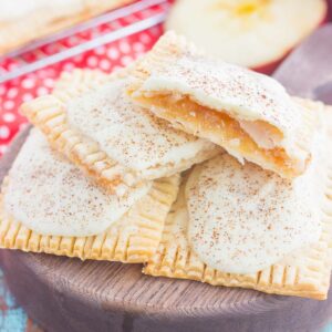 These Apple Pie Pop Tarts are an easy treat that's perfect for breakfast or dessert. Flaky pie crust surrounds sweet apple pie filling and is frosted with white chocolate and apple pie spice. Simple to make and better than the store-bought kind, you'll love the cozy taste of these homemade pop tarts!