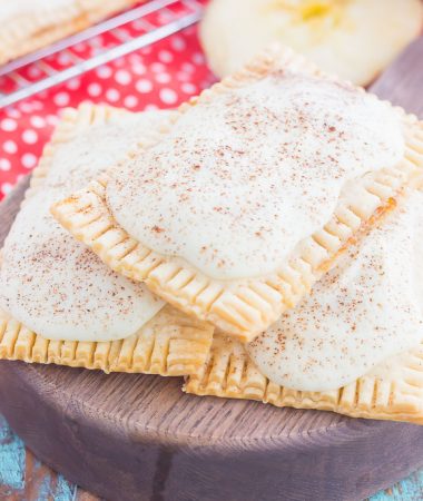 These Apple Pie Pop Tarts are an easy treat that's perfect for breakfast or dessert. Flaky pie crust surrounds sweet apple pie filling and is frosted with white chocolate and apple pie spice. Simple to make and better than the store-bought kind, you'll love the cozy taste of these homemade pop tarts!