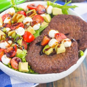 This Avocado Caprese Burger Salad is a healthier way to switch up your meal routine. It's packed with diced avocado, cherry tomatoes, mozzarella pearls, veggie burgers and drizzled with a sweet balsamic glaze. Simple to make and perfect for just about any time, you'll love the delicious taste of this flavorful salad!