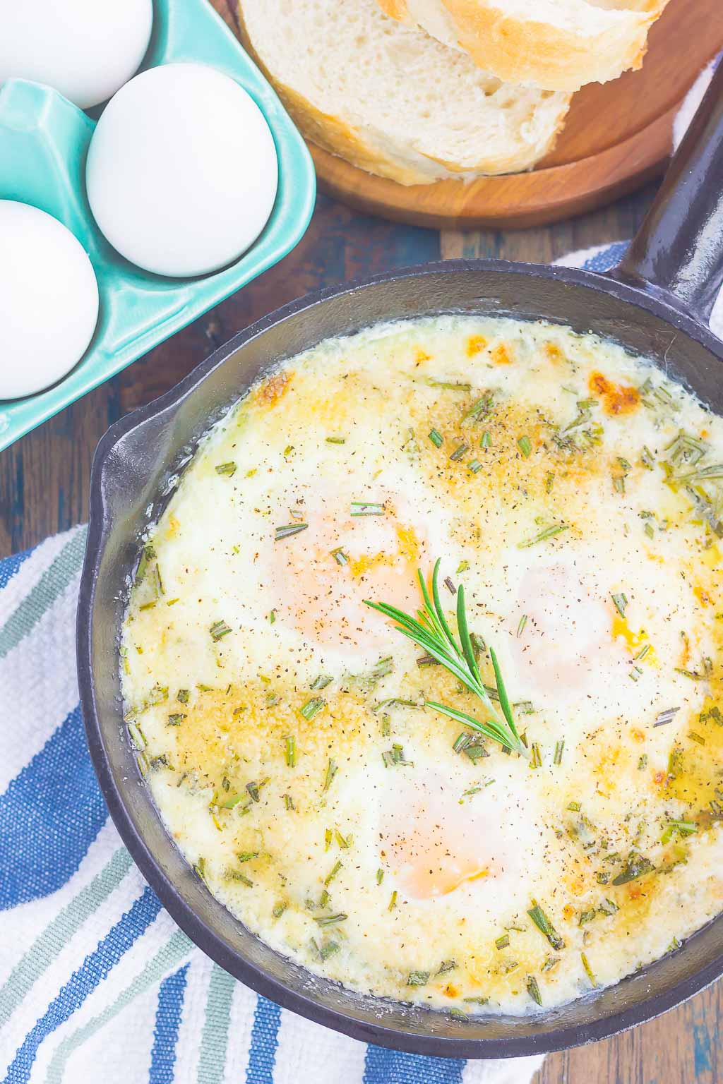 Baked Eggs with Rosemary and Thyme make a simple breakfast that's loaded with flavor. Fresh herbs and a sprinkling of cheese give this dish a savory blend that's perfect for a cozy dish. Serve with a side of crusty bread and this will quickly become a new favorite!