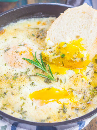 Baked Eggs with Rosemary and Thyme make a simple breakfast that's loaded with flavor. Fresh herbs and a sprinkling of cheese give this dish a savory blend that's perfect for a cozy dish. Serve with a side of crusty bread and this will quickly become a new favorite!