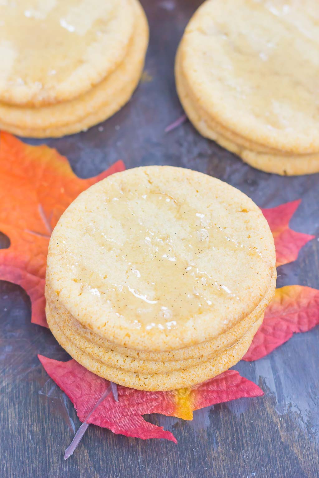 Three stacks of maple syrup cookies topped with maple glaze. 